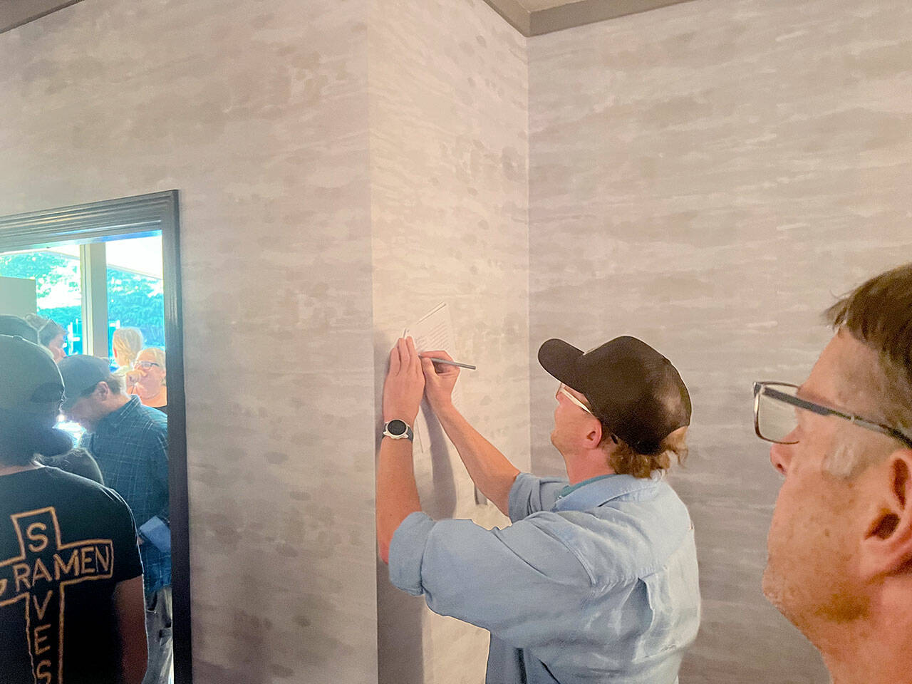 Eric Coufal signs a letter urging Olympic National Park officials to ensure access to Hurricane Ridge this winter. Locals have been concerned about winter access after the ridge’s day lodge burned down in May. A local coalition held a meeting at the Red Lion Hotel in Port Angeles on Wednesday to discuss the situation. (Peter Segall/Peninsula Daily News)