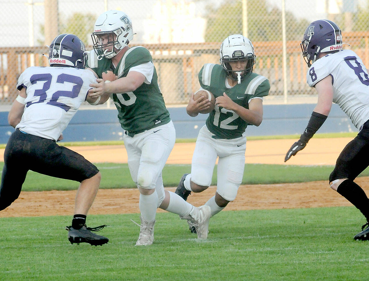 Port Angeles’ Kason Albaugh, center, gets a block from teammate Landyn Jones as Anacortes’ defenders Brock Beaner, left, and Braden Thomas close in during the first quarter on Friday in Port Angeles. (Keith Thorpe/Peninsula Daily News)