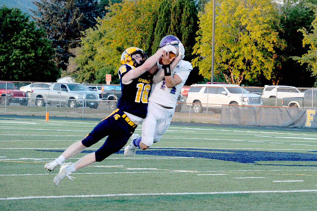 Spartan Gunner Rogers (16) and Sequim's Zeke Schmadeke (14) pull in a Forks pass for joint possession.  Joint possession goes to the offense giving Forks a first down.  (Lonnie Archibald/for Peninsula Daily News)