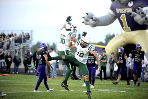 Port Angeles’ Tanner Flores (56) and Kason Albaugh (12) celebrate a big play in the Rainshadow Rumble in Sequim on Friday night. The Roughriders won the game 37-10, avenging last year’s last-second win by the Wolves. For a game story, go to Page A6. (Michael Dashiell/Olympic Peninsula News Group)