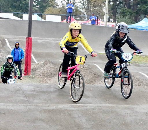 Abel Grant of Marysville (1) and Sophia McCain of Spokane (38) are in tight race in the girls division of the BMX state championships on Sunday at the Lincoln Park BMX track in Port Angeles. Hundreds of racers visited the North Olympic Peninsula for the event this weekend. (Dave Logan/for Peninsula Daily News)