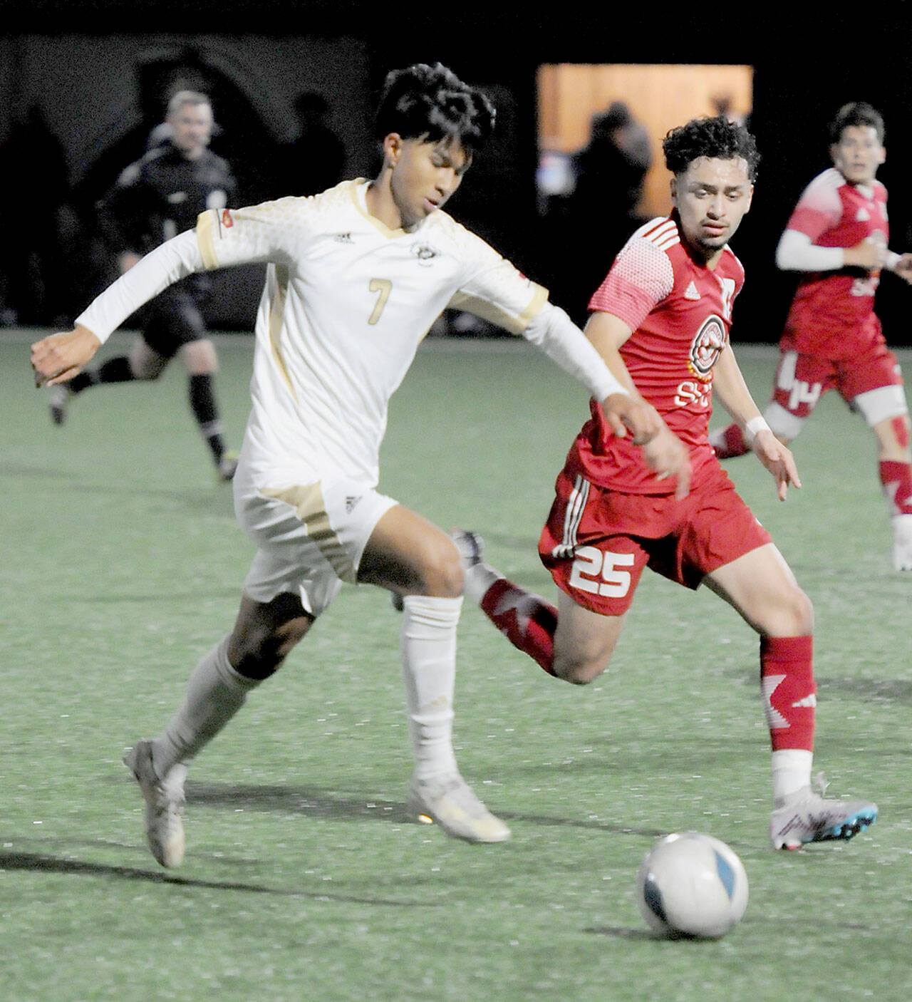 Peninsula’s Matthew Enriquez, left, tries to stay ahead of the defense of Skagit Valley’s Nick Kapp on Wednesday in Port Angeles. (Keith Thorpe/Peninsula Daily News)