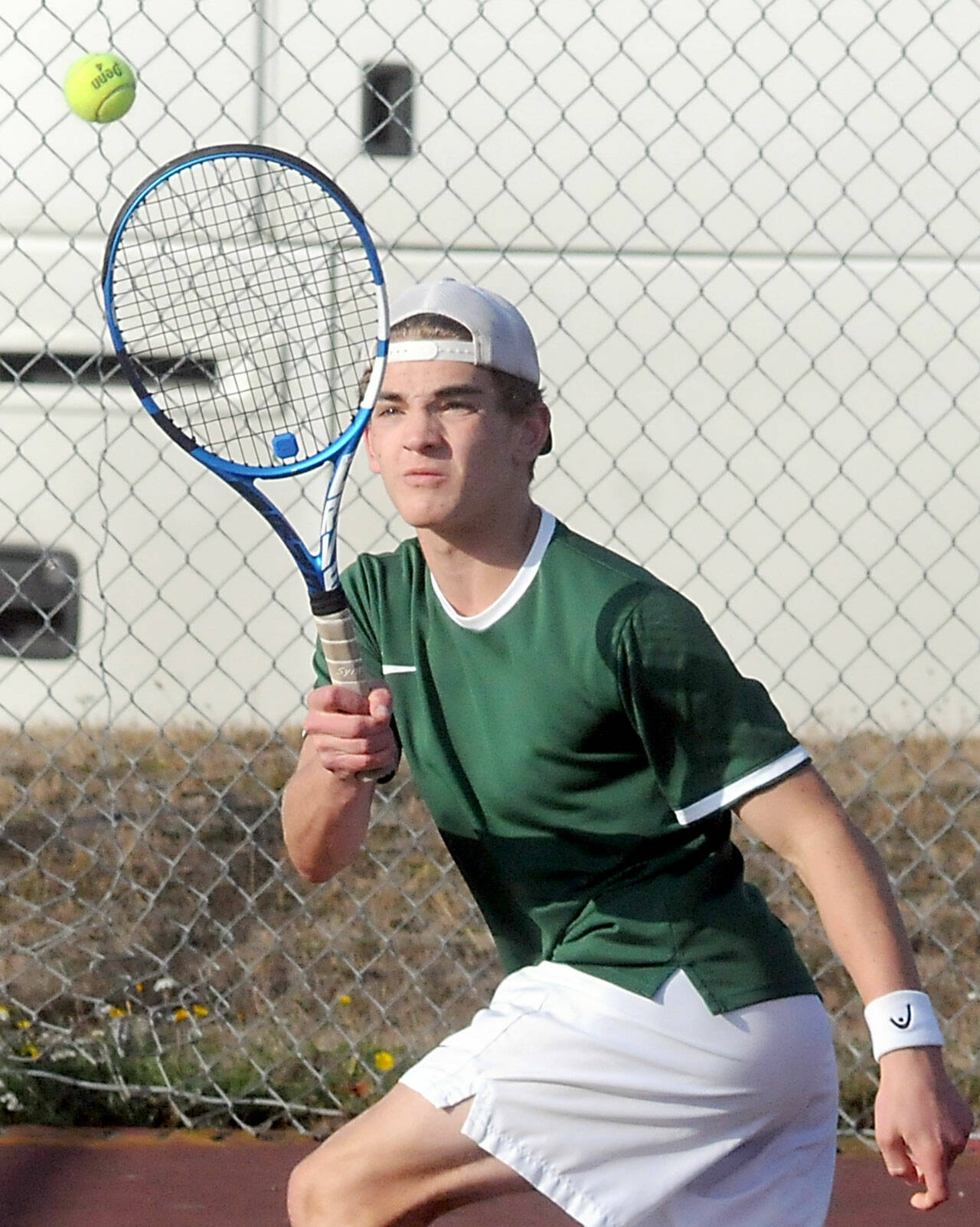 KEITH THORPE/PENINSULA DAILY NEWS Port Angeles’ Nathan Basden gets the return in his singles match against Olympic’s Jonah Pantig on Thursday at Port Angeles High School.