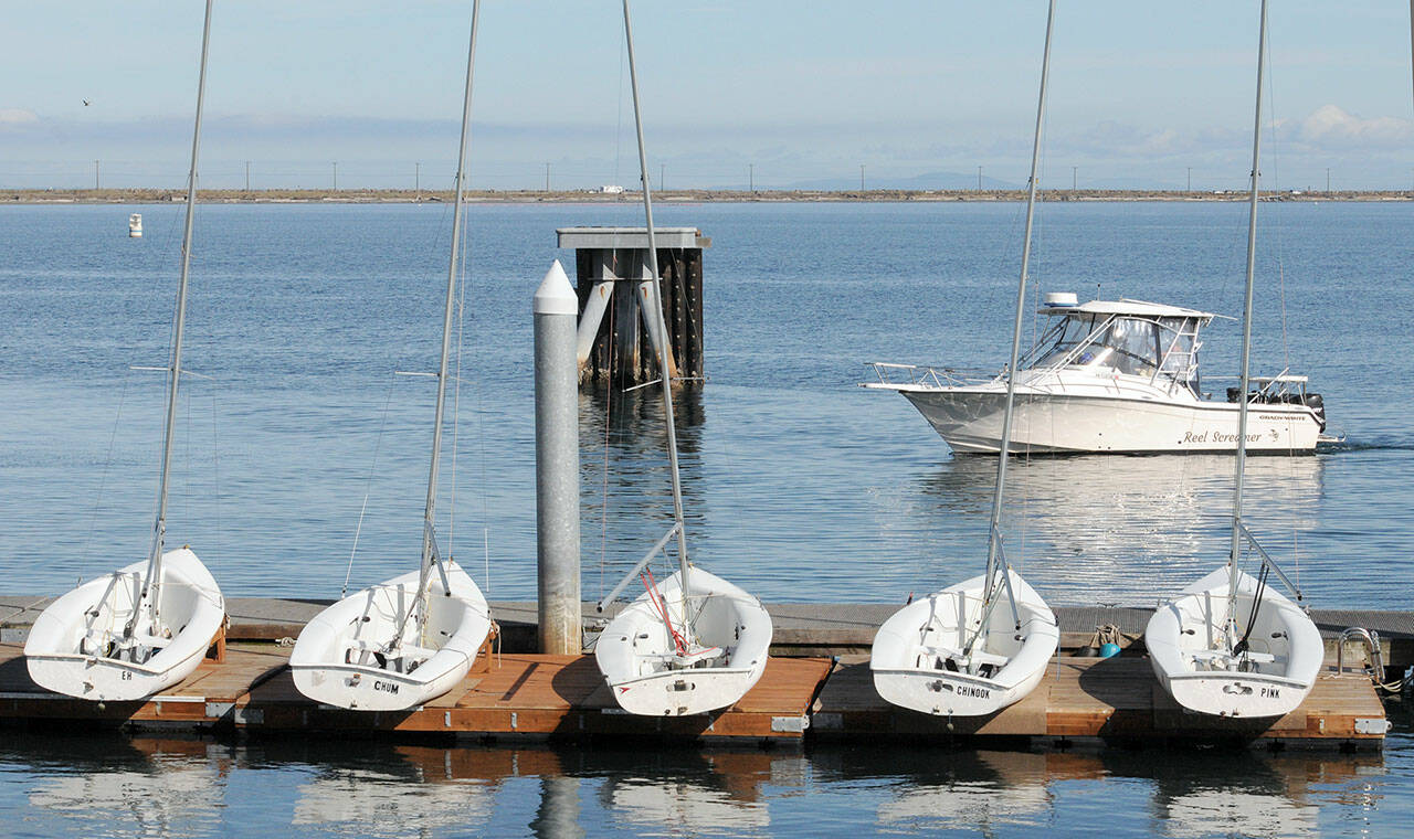 A fishing boat makes its way to the ramp at Port Angeles Boat Haven on Tuesday past a line of small sailboats belonging to the Community Boating Program for learn-to-sail classes. As the sailing season nears its end, the Port of Port Angeles plans to remove the floating docks at Boat Haven for the winter season on Oct. 16. (Keith Thorpe/Peninsula Daily News)