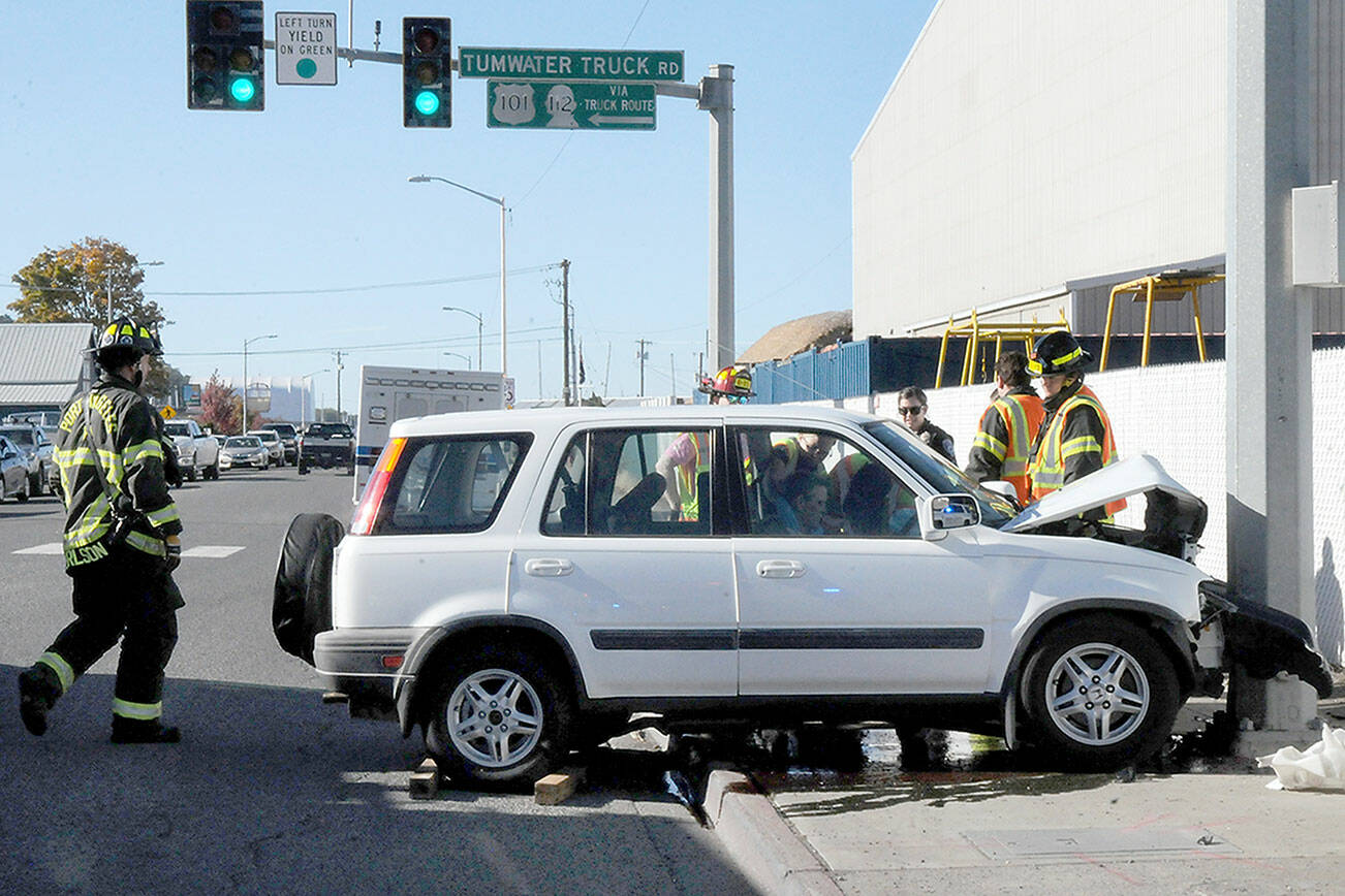 KEITH THORPE/PENINSULA DAILY NEWS
Port Angeles police and rescue workers assist the driver of a vehicle that crashed into a traffic light support pole at Marine Drive and the Tumwater Truck Route at abut 3:30 p.m. Thursday. No more information was available as of Friday.