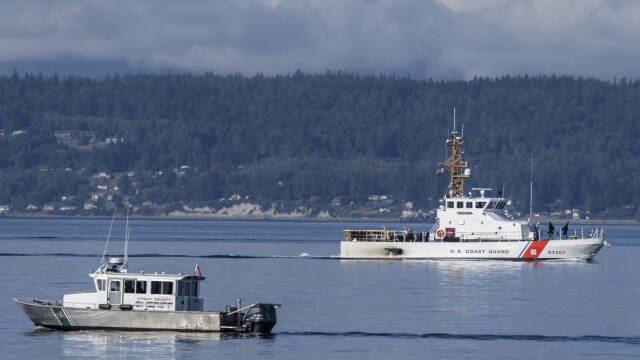 FILE - A U.S. Coast Guard boat and Kitsap, Wash., County Sheriff boat search an area, Monday, Sept. 5, 2022, near Freeland, Wash., on Whidbey Island north of Seattle where a chartered floatplane crashed the day before, killing 10 people. On Thursday, Oct. 5, 2023, the National Transportation Safety Board confirmed that a mechanical issue caused the seaplane to crash. (AP Photo/Stephen Brashear, File)