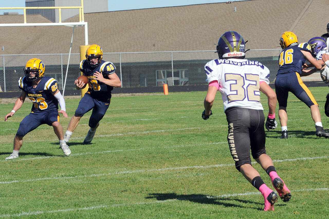 With Spartans Walker Wheeler (63) and Brody Lausche (46) blocking, Forks running back Nate Dahlgren picks up good yardage against Friday Harbor in a nonleague game played Saturday afternoon in Sequim. (Lonnie Arachibald/for Peninsula Daily News)