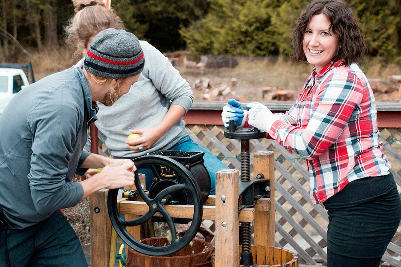 Local resident Sheana Joy Walvatne uses an apple press at the Olympic Peninsula Apple and Cider Festival in 2022.