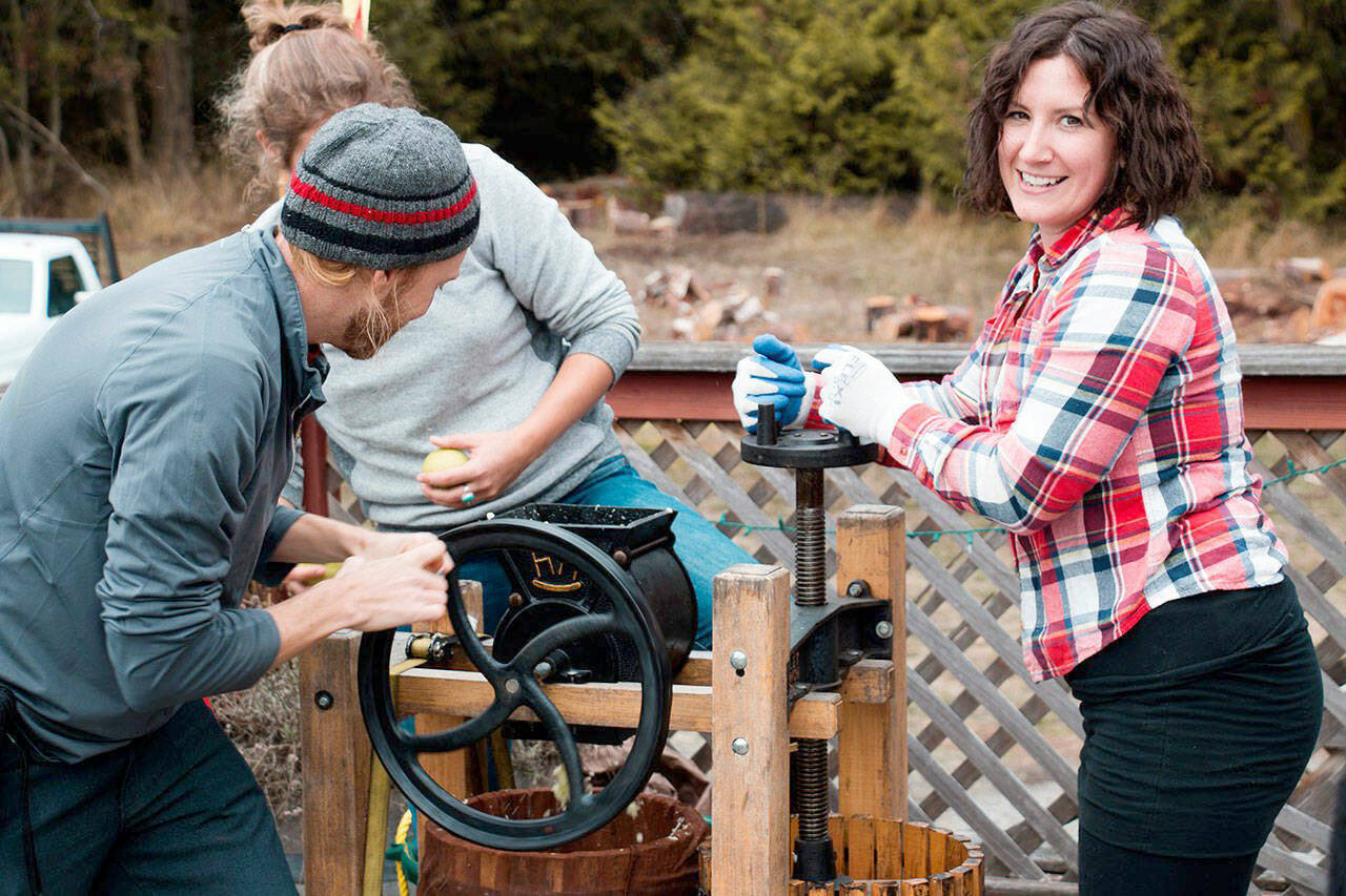 Local resident Sheana Joy Walvatne uses an apple press at the Olympic Peninsula Apple and Cider Festival in 2022.