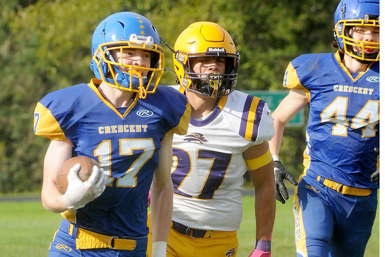 KEITH THORPE/PENINSULA DAILY NEWS
Crescent's Lukas Love, left, sprints for the end zone pursued by Concrete's Adam Culver, center, and teammate Carter Clifford on Saturday in Joyce.