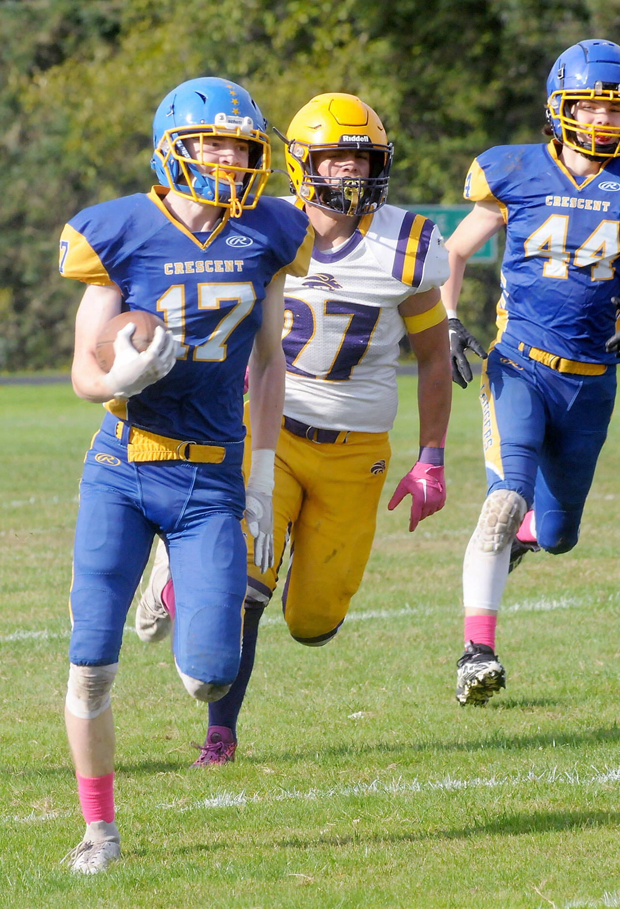 KEITH THORPE/PENINSULA DAILY NEWS Crescent’s Lukas Love, left, sprints for the end zone pursued by Concrete’s Adam Culver, center, and teammate Carter Clifford on Saturday in Joyce.
