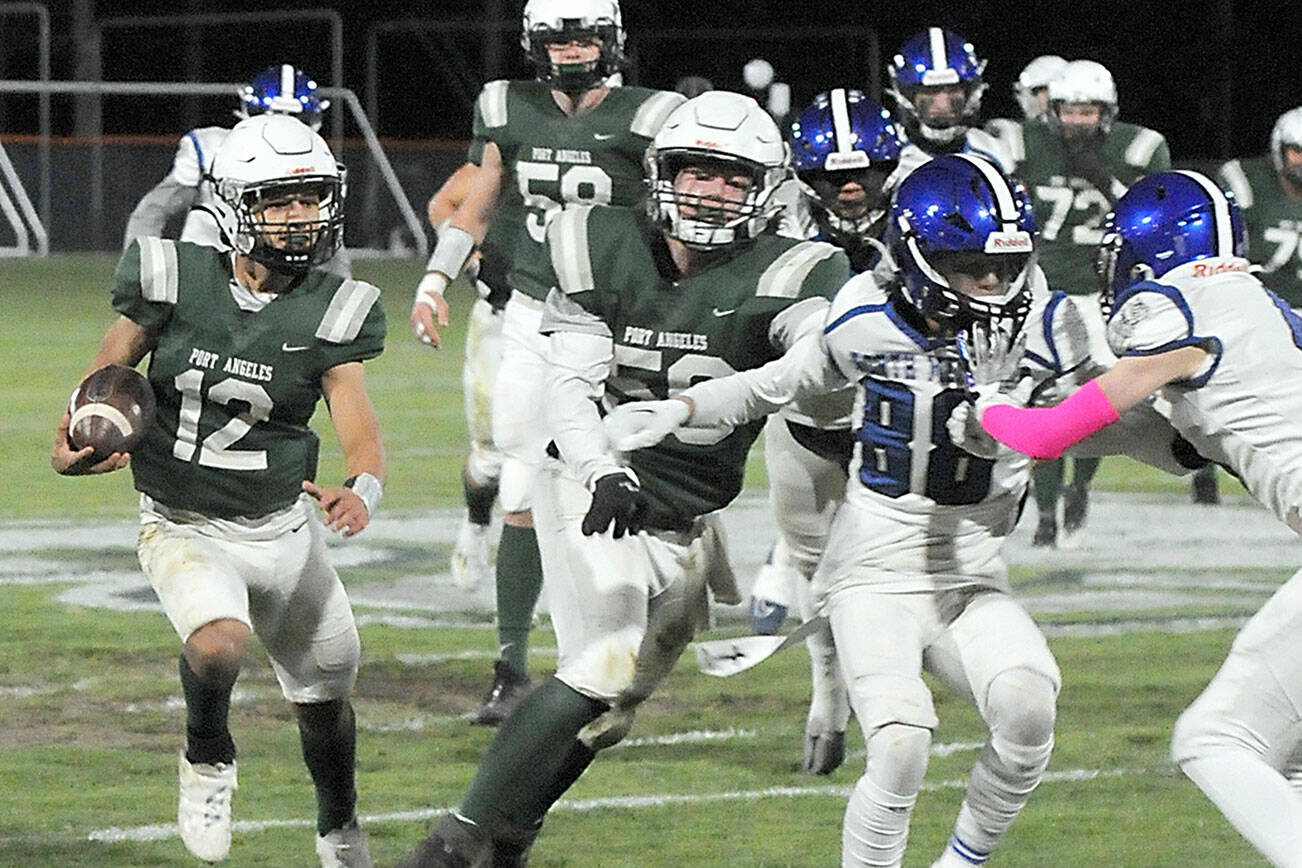 KEITH THORPE/PENINSULA DAILY NEWS
Port Angeles' Kason Albaugh, left, receives a block from teammate Tanner Flores as the North Mason defense closes in during Friday's game at Port Angeles Civic Field.