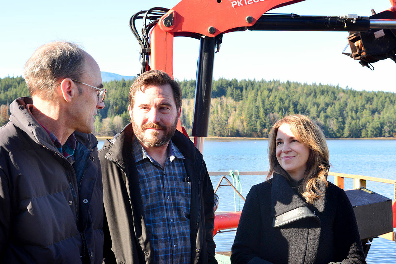 Celebrating the expansion of the Dabob Bay Natural Area by adding 671 acres to the state’s new carbon sequestration program are, from left, Peter Bahls, Northwest Watershed Institute executive director; Jefferson County Commissioner Greg Brotherton; and state Commissioner of Public Lands Hilary Franz at an oyster farm on Dabob Bay. (Peter Segall/Peninsula Daily News)