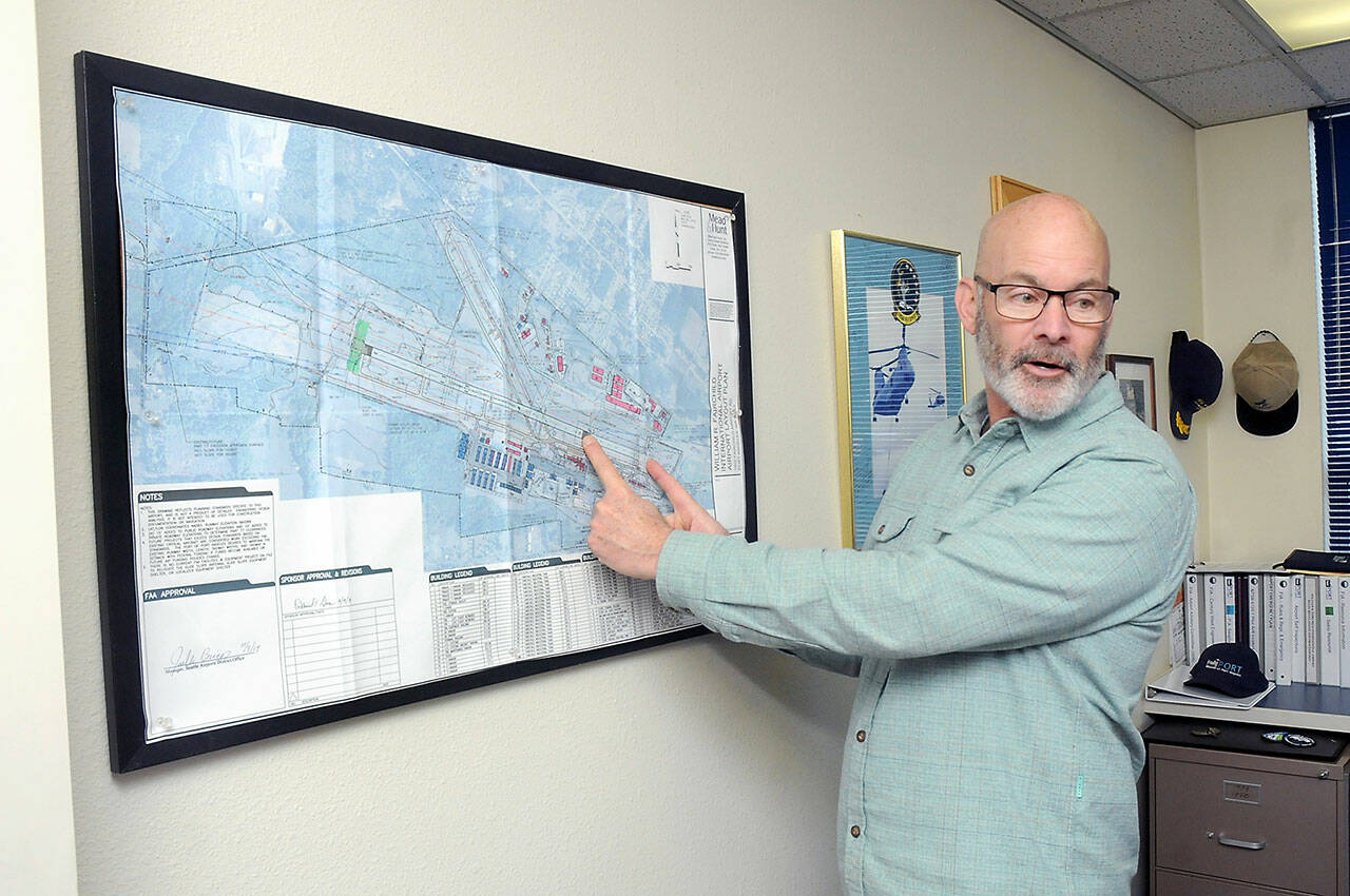 Jon Picker, airport and marina manager for the Port of Port Angeles, describes runway sections for William R. Fairchild International Airport on a diagram of the terminal area. (Keith Thorpe/Peninsula Daily News)