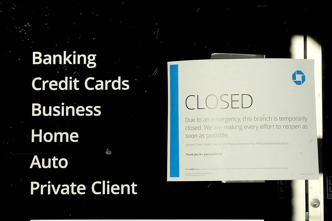 KEITH THORPE/PENINSULA DAILY NEWS
 A closed sign is taped to the front door of the Chase Bank branch in downtown Port Angeles on Friday, citing an "emergency" brought on by a lack of internet service.