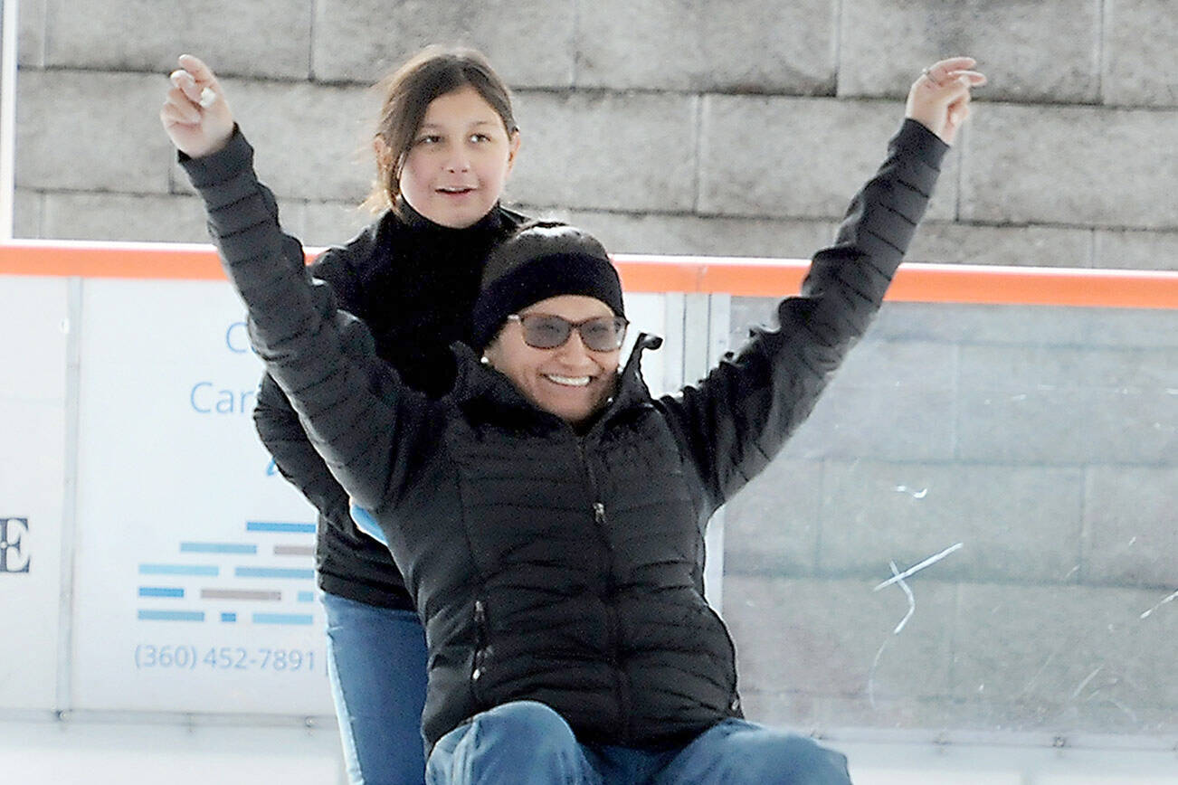 Sharmaine Wright of Port Angeles expresses delight while being pushed by her daughter, Kaylee Konopaski, 10, on the ice at the Port Angeles Winter Ice Village on Saturday. The village, which features a temporary ice skating rink, opened Friday and will operate daily from noon to 9 p.m. through Jan. 2. (Keith Thorpe/Peninsula Daily News)