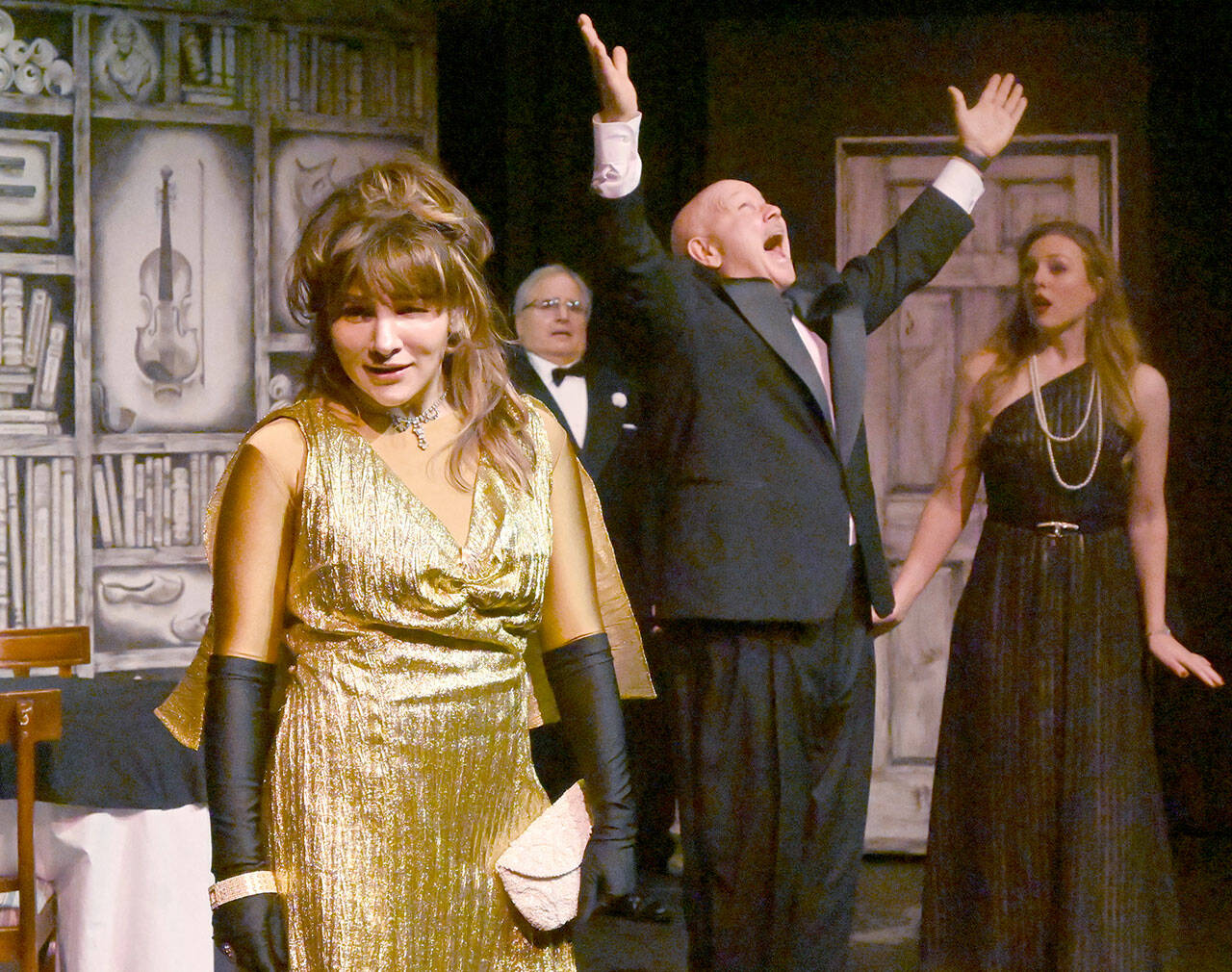 Acerbic magazine columnist Daria Chase (portrayed by Jamie Pauley) reveals that newly-married Simon Bright (Stephan Willms) has inherited a fortune in an early scene of “The Game’s Afoot or Holmes for the Holidays.” Looking on are host William Gillette (Joel Hoffman) and Bright’s new bride, Aggie Wheeler (Merrin Packer). (Michael Dashiell/Olympic Peninsula News Group)