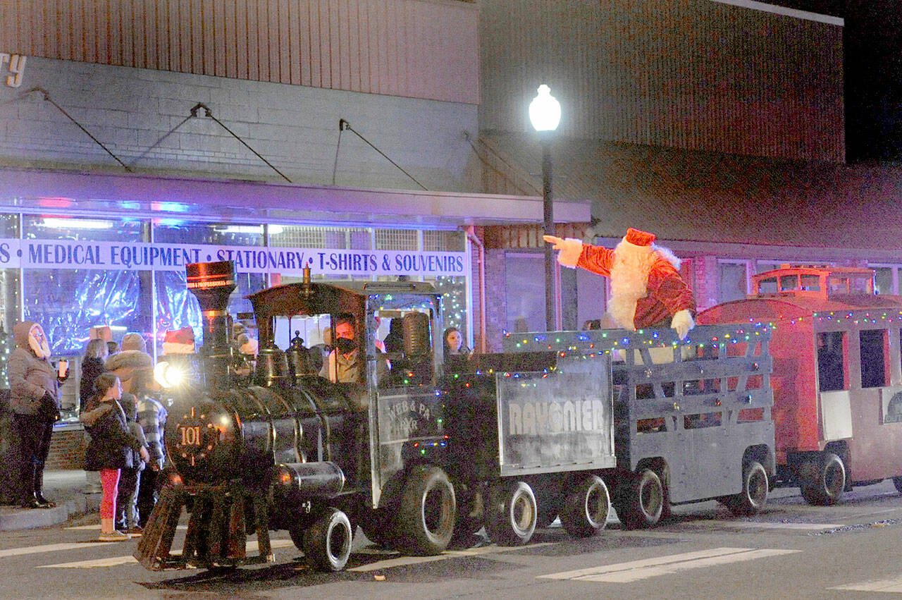 Santa rides down Forks Avenue during the Twinkle Light Parade in 2022 in the West End Business & Professional association train. (Lonnie Archibald/for Peninsula Daily News, file)