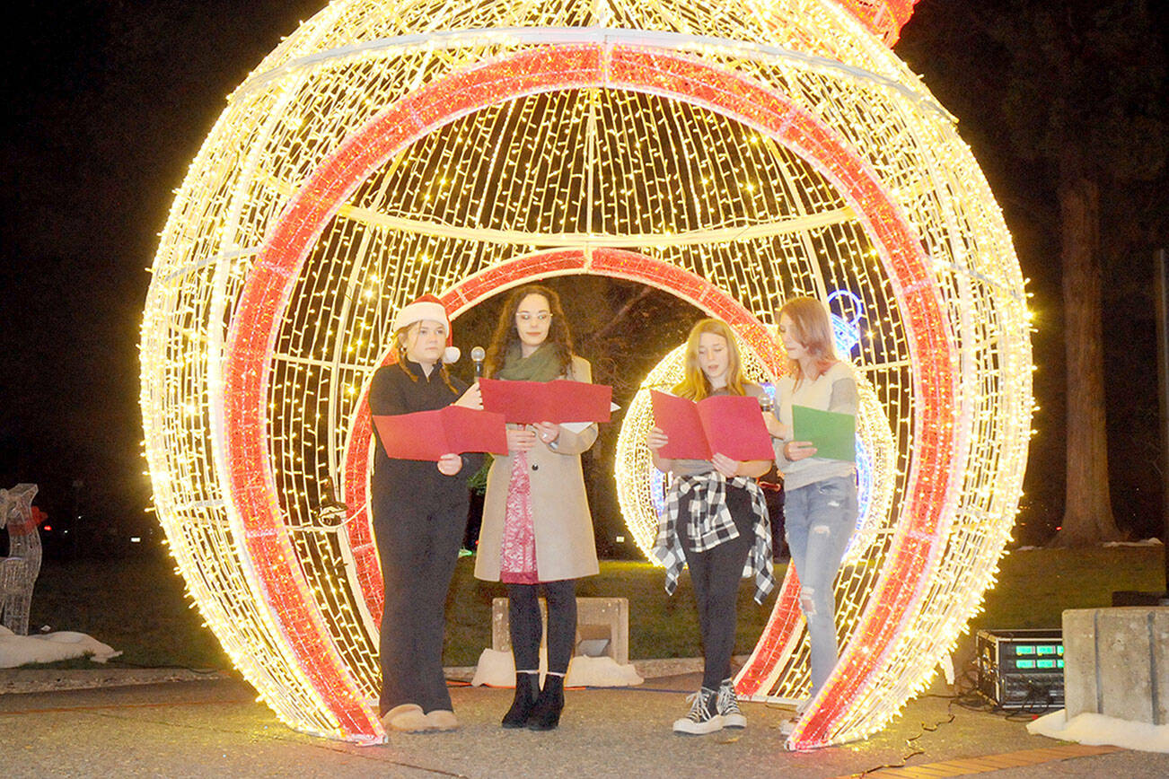 Singers, from left, Abbigail Cuellar, 16, Danielle Lorentzen of Ghostlight Productions, Kaylyn Stroup, 15, and Max MacFall, 15, perform a Christmas carol during Wednesday evening’s opening ceremony for the 33rd annual Festival of Trees at Vern Burton Community Center in Port Angeles. (Keith Thorpe/Peninsula Daily News)