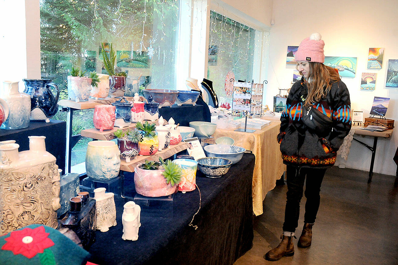 KEITH THORPE/PENINSULA DAILY NEWS
Melissa Montague of Corvallis, Ore., examines tables filled with locally-made gifts at the Makers Market on Friday at the Port Angeles Fine Arts Center.