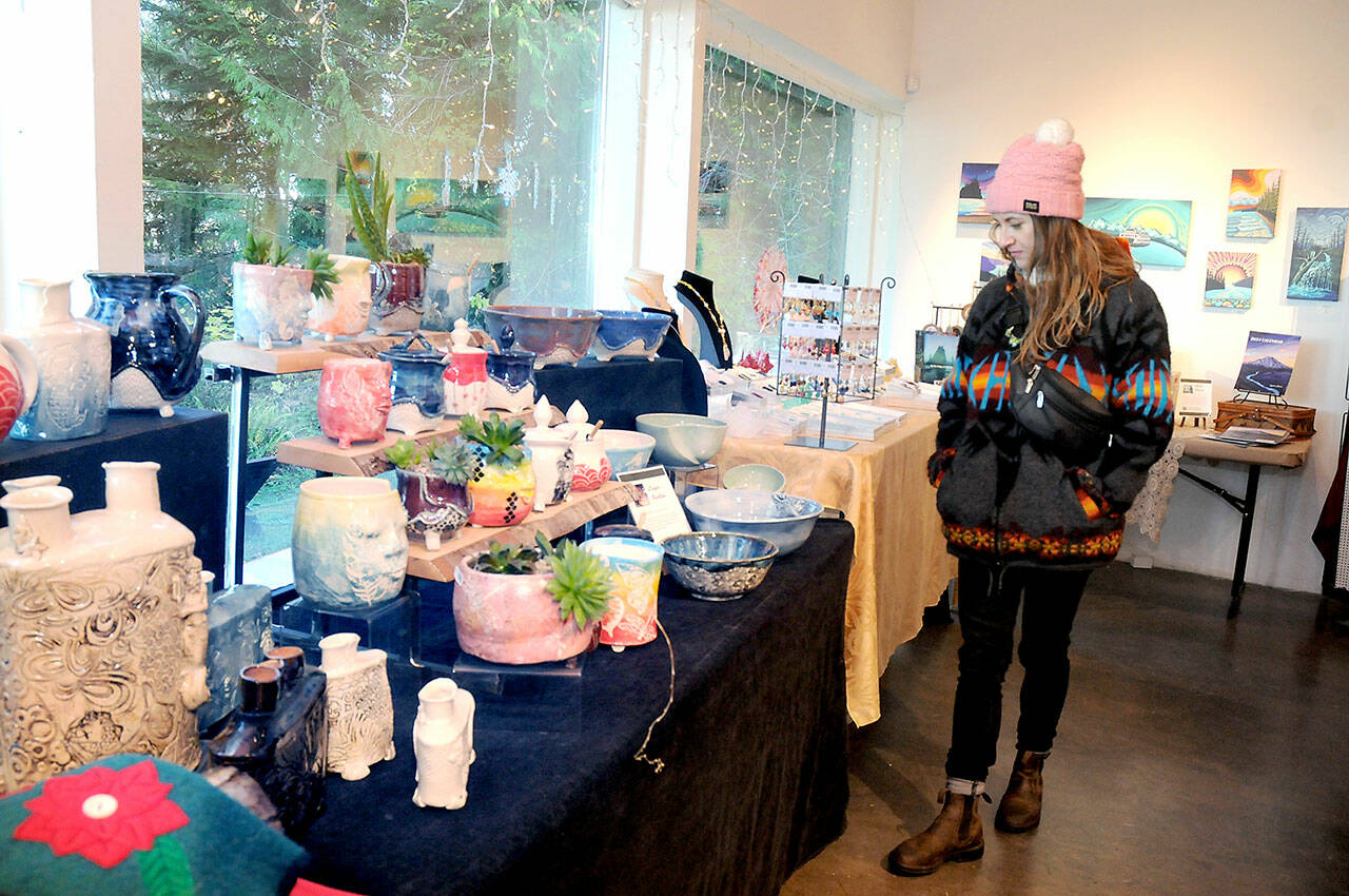 Melissa Montague of Corvallis, Ore., examines tables filled with locally-made gifts at the Makers Market on Friday at the Port Angeles Fine Arts Center. (KEITH THORPE/PENINSULA DAILY NEWS)