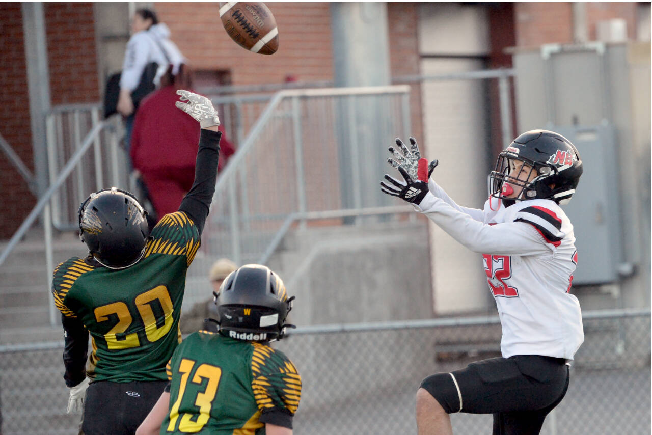 Neah Bay's Adan Ellis goes for a reception at the Apple Bowl in Wenatchee in the state 1B semifinal football game. Ellis had three touchdown catches in the game. Defending on the play are Liberty Bell's Bodie Thompson (20) and Greyden Paz (13). (Al Camp)