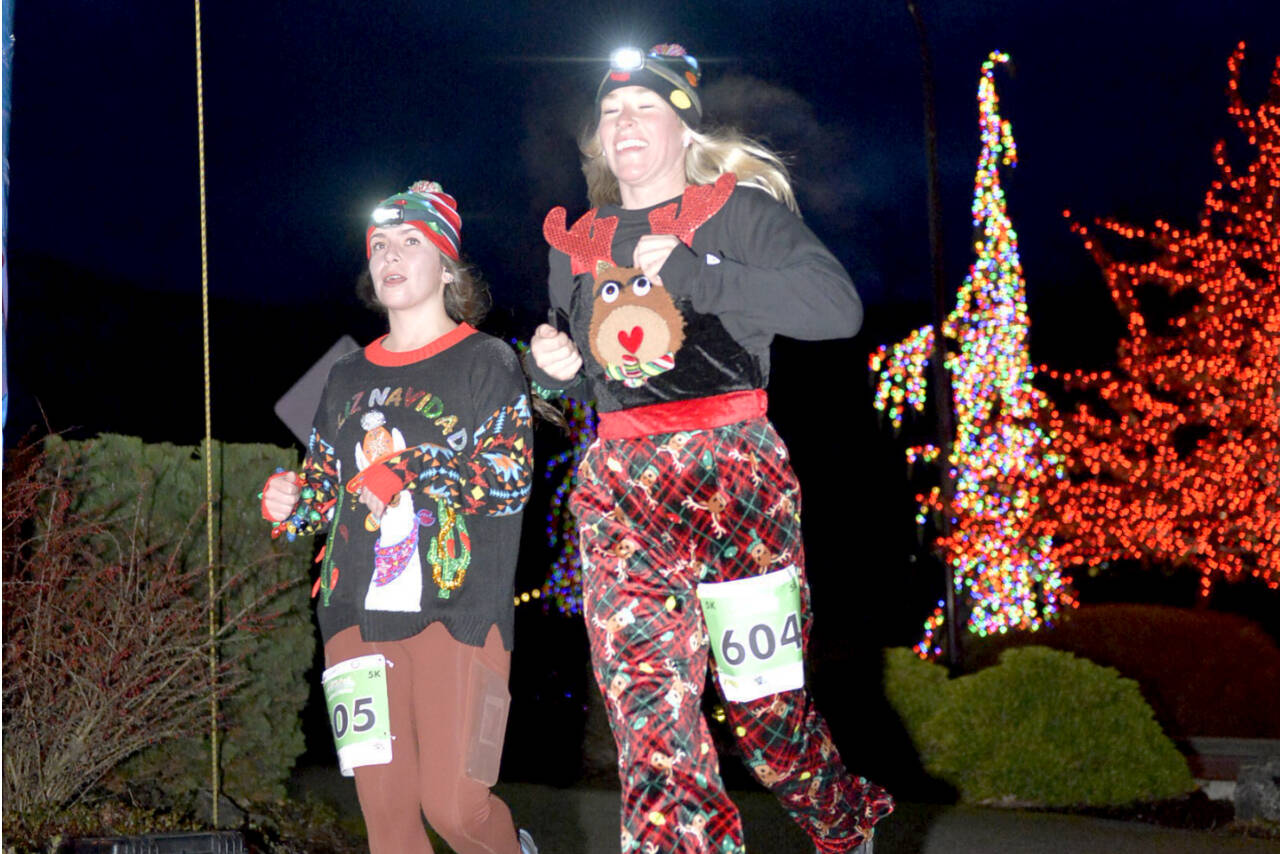 Sami Nolan, left, and Chelsea Pluard, both of Port Angeles, finish the 5K in the 2022 edition of the Jamestown S’Klallam Glow Run in Blyn. The race returns Saturday afternoon and evening. (Run the Peninsula)
