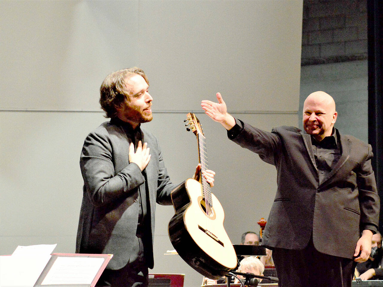 Guitarist Colin Davin, left, stands beside Port Angeles Symphony conductor Jonathan Pasternack, after stepping in at the last minute to perform with the orchestra in December 2021. Davin will rejoin the symphony for its Holiday Concert this Saturday. (Diane Urbani de la Paz/for Peninsula Daily News)