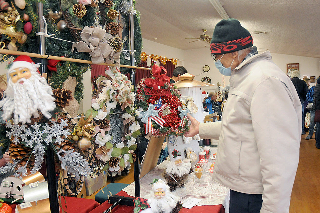 Arthur Seward of Sequim examines a display of handmade wreaths created by Sequim-based The Hitching Post during Saturday’s Holiday Craft Fair at the Sequim Prairie Grange near Carlsborg. The fair featured a variety of holiday-themed crafts and gifts made by local artisans, as well as lunch prepared by grange members. (Keith Thorpe/Peninsula Daily News)