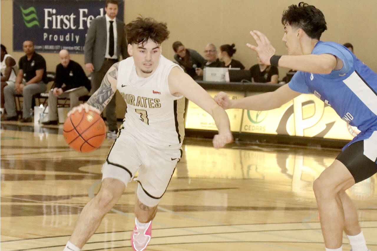 Peninsula College’s Aiden Olmstead drives against the defense of South Puget Sound as Peninsula head coach Bryce Jacobson, background, watches the play. (Dave Logan/for Peninsula Daily News)