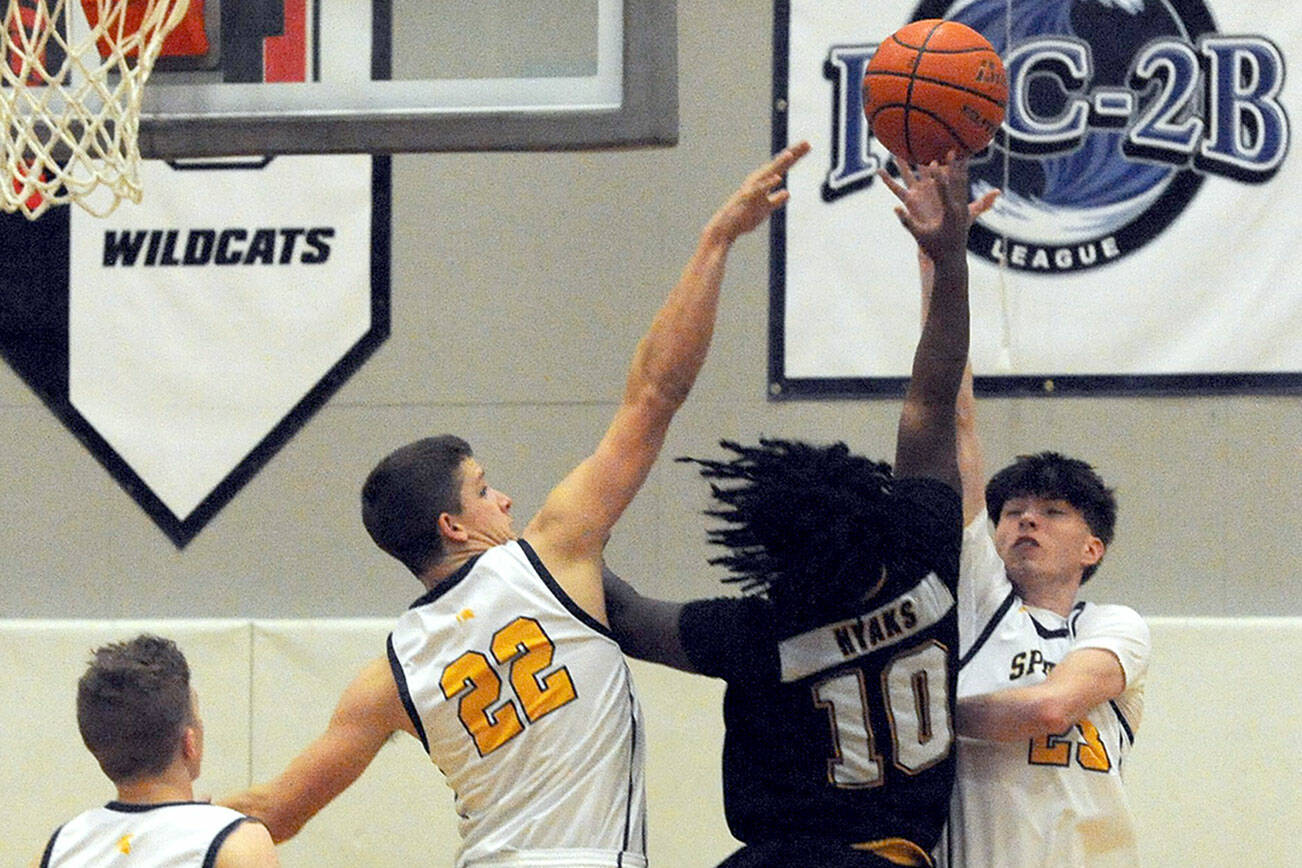 Spartans Brody Lausche (22) and Isaac Gonzales defend against Hyak Tyrrell Curry-Sith on Wednesday evening in Forks, where the Spartans beat North Beach 48-41. Also in the action is Spartan Landen Olson. (Lonnie Archibald/for Peninsula Daily News)