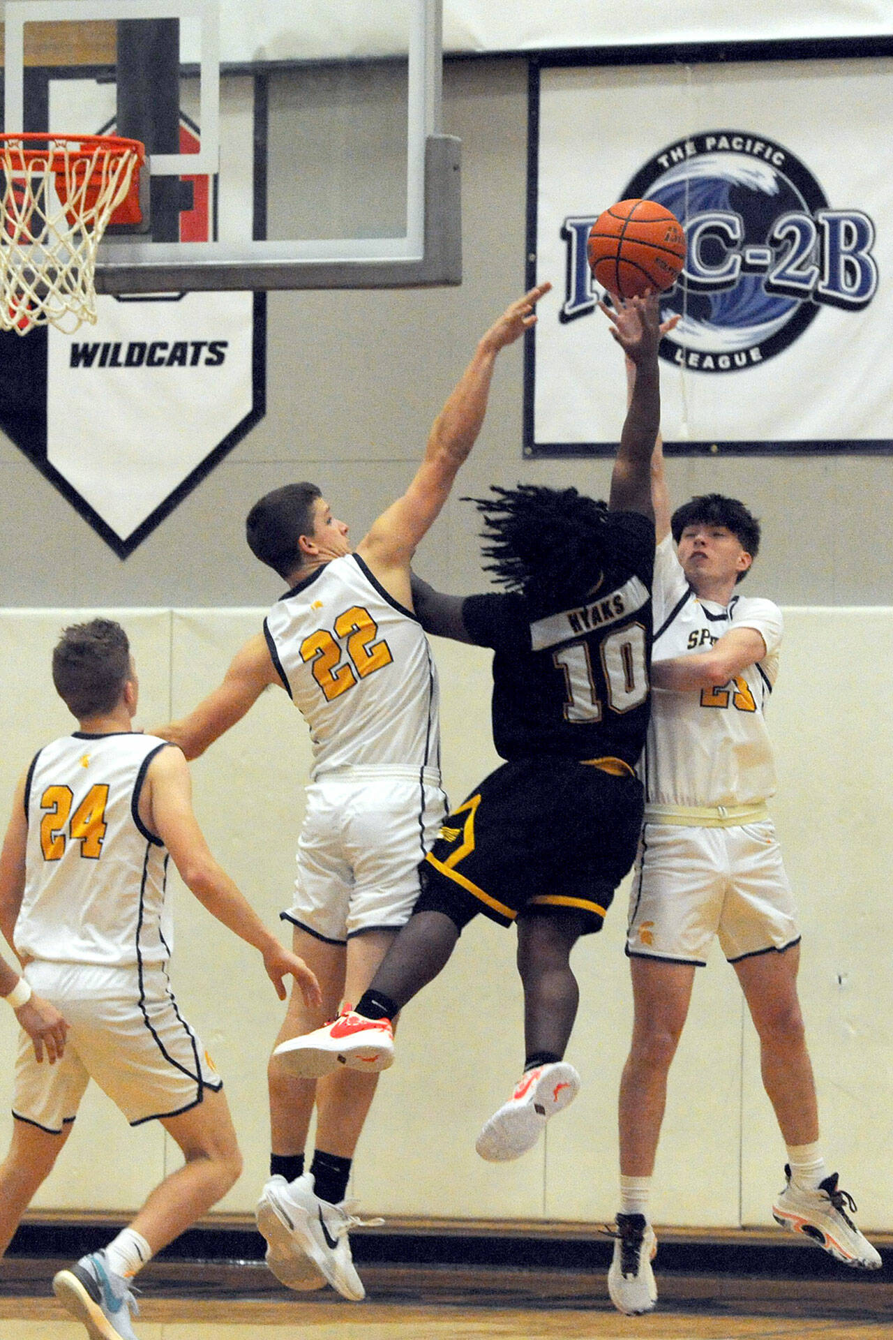 Spartans Brody Lausche (22) and Isaac Gonzales defend against Hyak Tyrrell Curry-Sith on Wednesday evening in Forks, where the Spartans beat North Beach 48-41. Also in the action is Spartan Landen Olson. (Lonnie Archibald/for Peninsula Daily News)