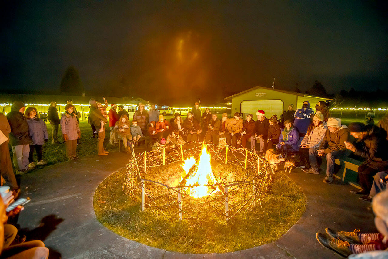 Several hundred people took advantage of a warming bonfire on the night of the Winter Solstice at the Jefferson County Fairgrounds on Thursday night. (Steve Mullensky/for Peninsula Daily News)