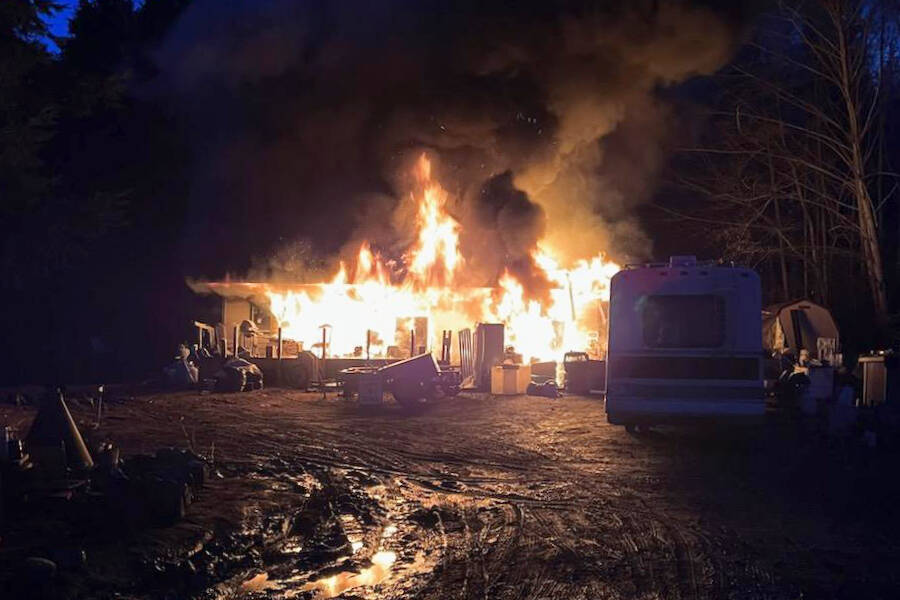 Clallam County Fire District 3 
Firefighters fight a house fire in the 900 block of Hooker Road on Wednesday. Law enforcement continued to seek a Sequim man suspected for the blaze on Thursday.