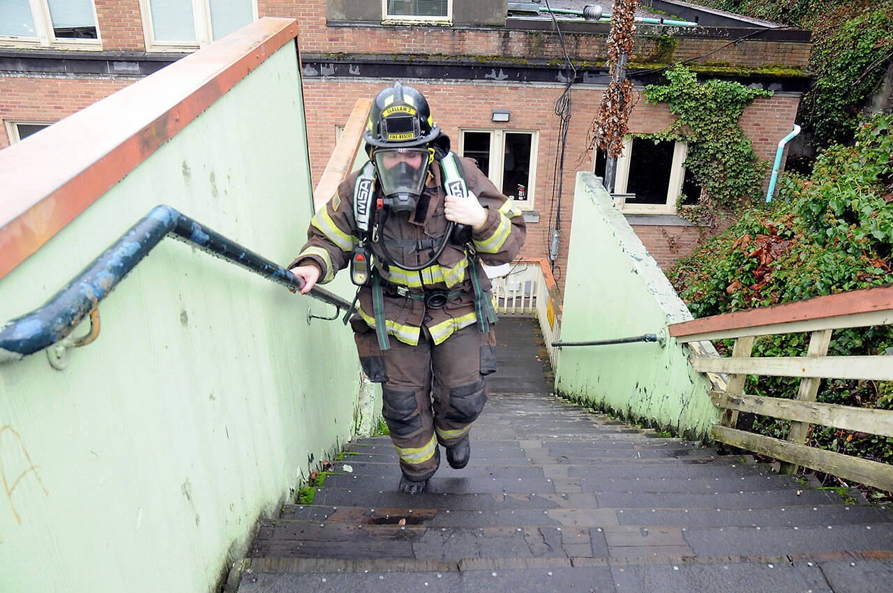 Clallam County Fire District 2 firefighter/EMT Anaka Hughes makes her way up the stairs behind the Conrad Dyar Memorial Fountain in Port Angeles on Saturday to gather donations and pledges supporting the upcoming Leukemia & Lymphoma Society Firefighter Stairclimb on March 10 at the Columbia Center in Seattle. The North Olympic Firefighters Team consisting of firefighters from Fire District 2 and the Port Angeles Fire Department will join about 2,000 firefighters from across the region in the event, ascending 69 floors with 1,356 steps of Seattle’s tallest skyscraper benefiting blood cancer research and patient services. The North Olympic team plans another fundraising event with stairclimb machines on March 10 at Bourbon West, 125 W. Front St. in Port Angeles. (Keith Thorpe/Peninsula Daily News)
