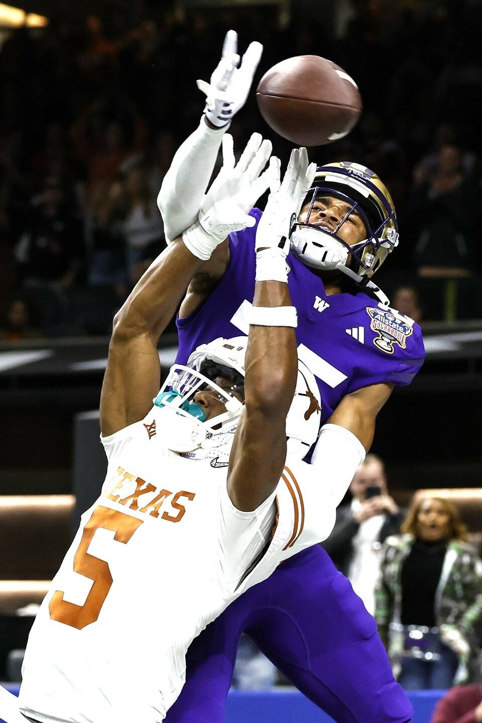 Washington cornerback Elijah Jackson (25) hits the ball before Texas wide receiver Adonai Mitchell (5) can catch it on the final play of the Sugar Bowl CFP NCAA semifinal college football game between Washington and Texas on Monday in New Orleans. Washington won 37-31. (AP Photo/Butch Dill)