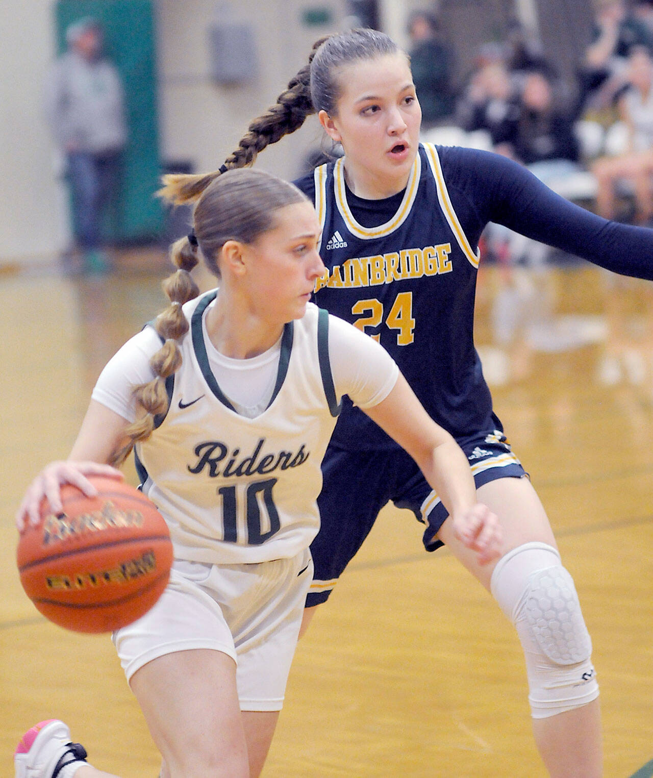 Port Angeles’ Teanna Clark, front, slips around the defense of Bainbridge’s Bella Ramirez during Tuesday’s game at Port Angeles High School. (Keith Thorpe/Peninsula Daily News)