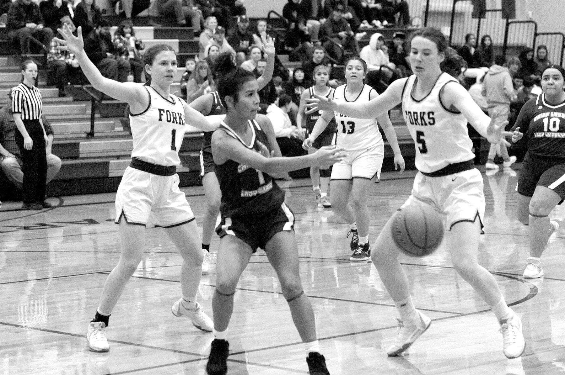 partan sisters Bailey Johnson (1) and Keira Johnson (5) get defensive against Chief Leschi in Forks where Forks defeated the Warriors 78 to 26.  Also in the action is Spartan Janessa Ramos (13).  Photo by Lonnie Archibald.