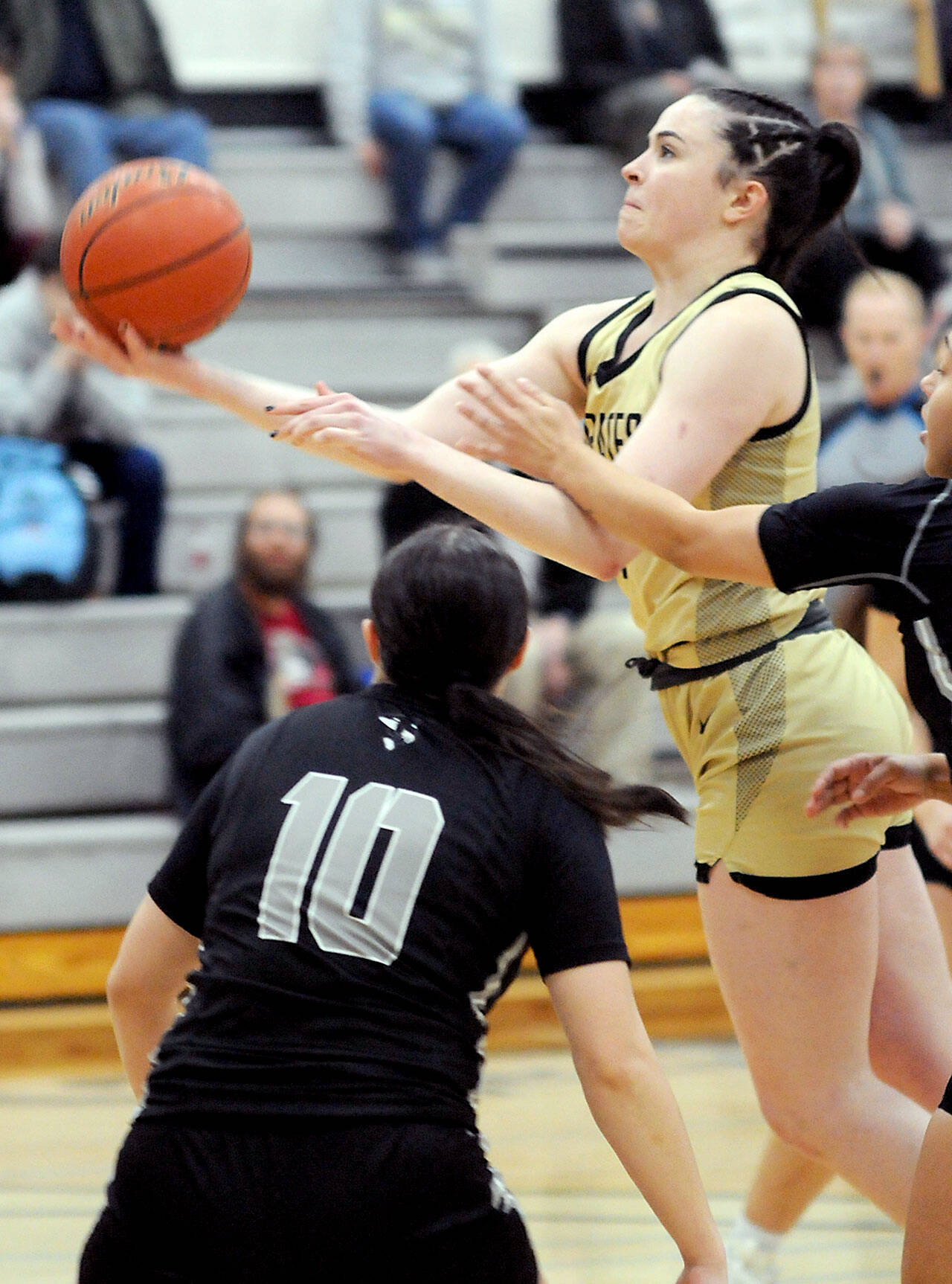 KEITH THORPE/PENINSULA DAILY NEWS Peninsula’s Alexa Mackey looks for the layin over the head of Whatcom’s Benemi Sanchez on Wednesday in Port Angeles.