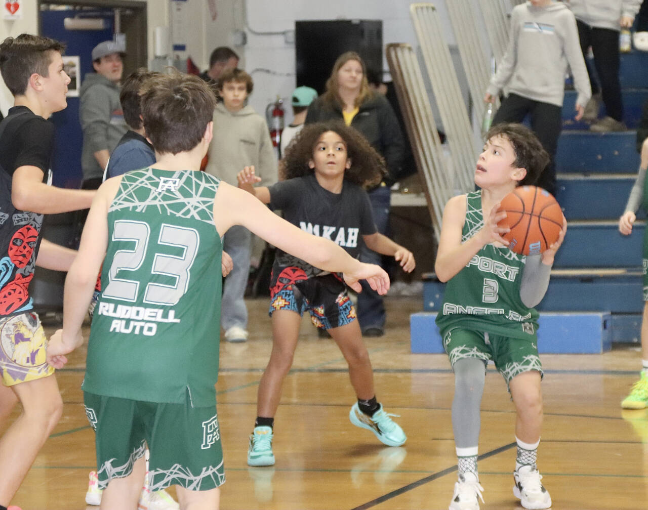Eighty teams, some from as far away as Anacortes, Stanwood and Enunclaw, braved the road conditions to play in the annual Port Angeles Martin Luther King Jr. youth basketball tournament Saturday and Sunday. Games were played at Stevens Middle School, Roosevelt Elementary, Dry Creek, Lower Elwha and Queen of Angels. Here, Port Angeles sixth-grader Justin Johnson (3) looks to the basket against a team from Neah Bay as Port Angeles’ Logan Garling (23) is in on the play. Neah Bay won 57-42 in the game played at Stevens Middle School. (Dave Logan/for Peninsula Daily News)