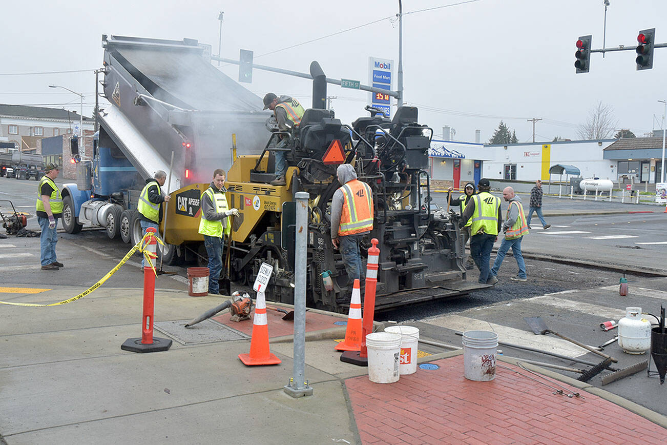 KEITH THORPE/PENINSULA DAILY NEWS 

A work crew from Lakeside Industries lays down a layer of asphalt to patch a sinkhole in the pavement at the intersection of Fifth and Lincoln streets in Port Angeles on Friday morning after the water from a broken 4-inch main collapsed the road surface on Wednesday morning. Port Angeles reopened the intersection on Friday afternoon. Ten customers lost water briefly but were back on the system and off a boil-water advisory by late Thursday.