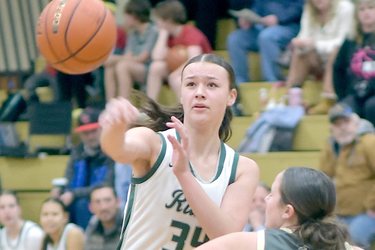 Port Angeles Lexie Smith, right, passes over the shoulder of North Kitsap’s Teegan DeVries on Tuesday evening at Port Angeles High School. (Keith Thorpe/Peninsula Daily News)