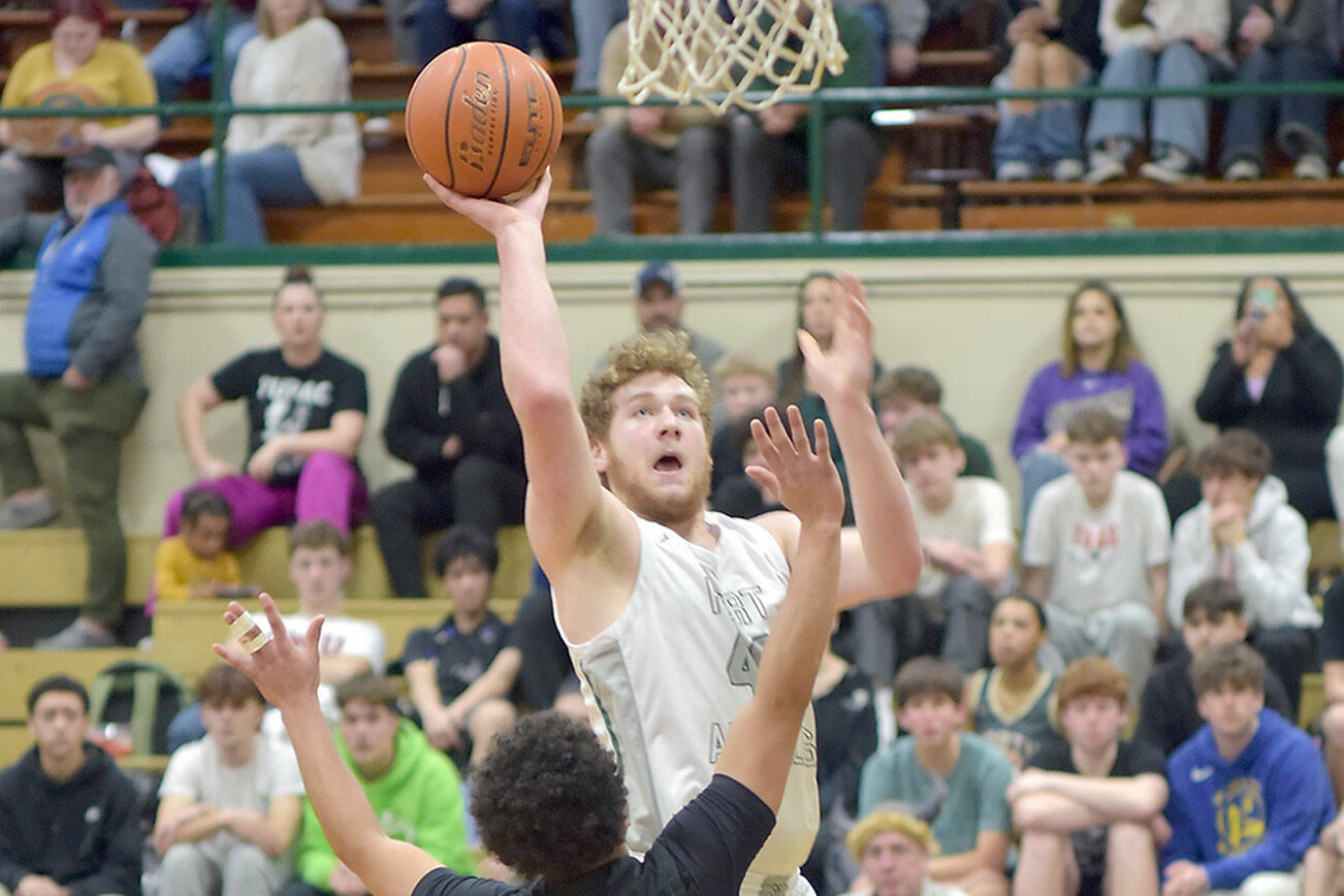 Port Angeles’ Isaiah Shamp aims for the basket as North Kitsap’s Jordan Williams defends the lane on Tuesday night at Port Angeles High School. (Keith Thorpe/Peninsula Daily News)