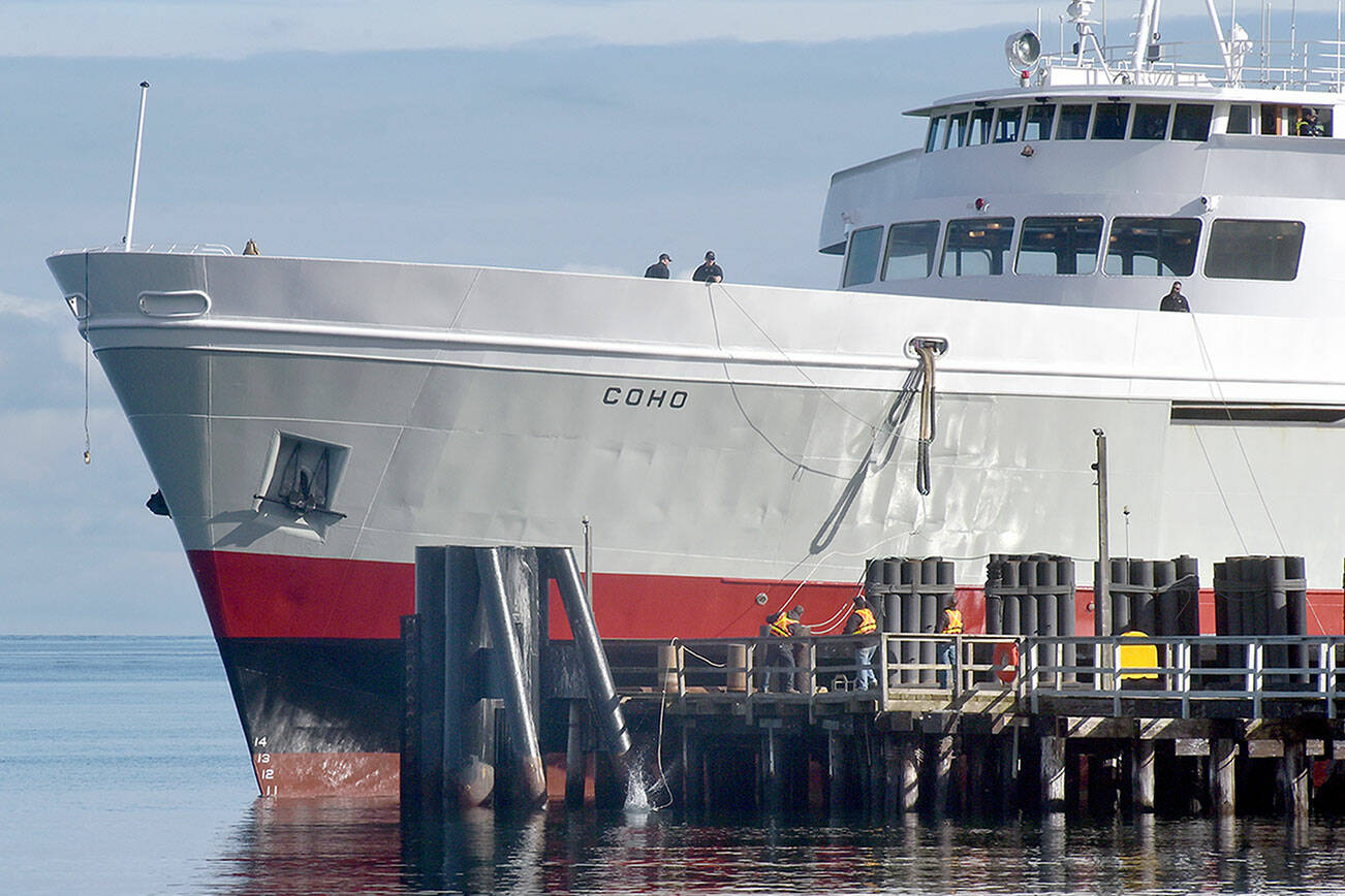 Crew members of the ferry MV Coho secure lines to the dock as the vessel returns to Port Angeles on Tuesday after being out of service since early January for annual dry dock and maintenance in Anacortes. The ferry is scheduled to resume daily service between Port Angeles and Victoria on Thursday. (Keith Thorpe/Peninsula Daily News)