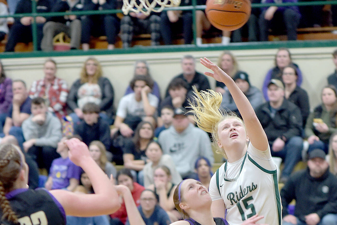KEITH THORPE/PENINSULA DAILY NEWS Port Angeles’ Paige Mason, right, puts up the ball over the head of Sequim’s Libby Turella as Sequim’s Hailey Wagner looks on at left on Tuesday at Port Angeles High School. Mason led the Roughriders with 26 points to help Port Angeles win 74-46 and clinch an Olympic League championship and a No. 1 seed for the playoffs. For the story, go to Sports on page B1.