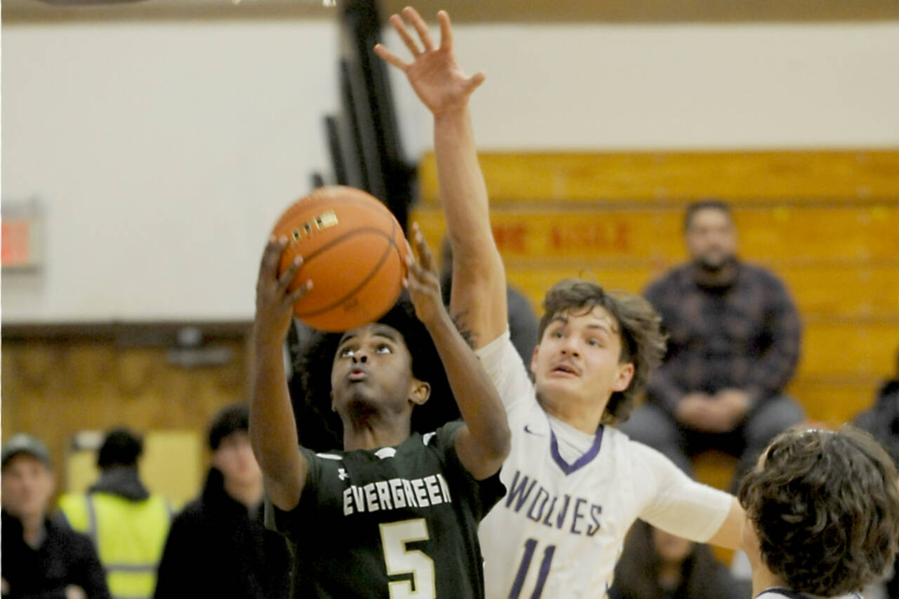 Sequim’s Charlie Grider (11) defends the rim against Evergreen’s Mohamed Abdi (5) in Tuesday’s bidistrict basketball playoff game in Sequim. (Michael Dashiell/Olympic Peninsula News Group)