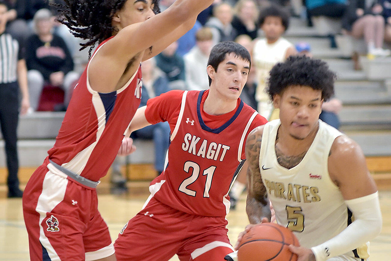 KEITH THORPE/PENINSULA DAILY NEWS
Peninsula's Jason Ervin, right, is held off by Skagit Valley's Sylas Williams, left, and Connor Drinkwine on Wednesday night in Port Angeles.