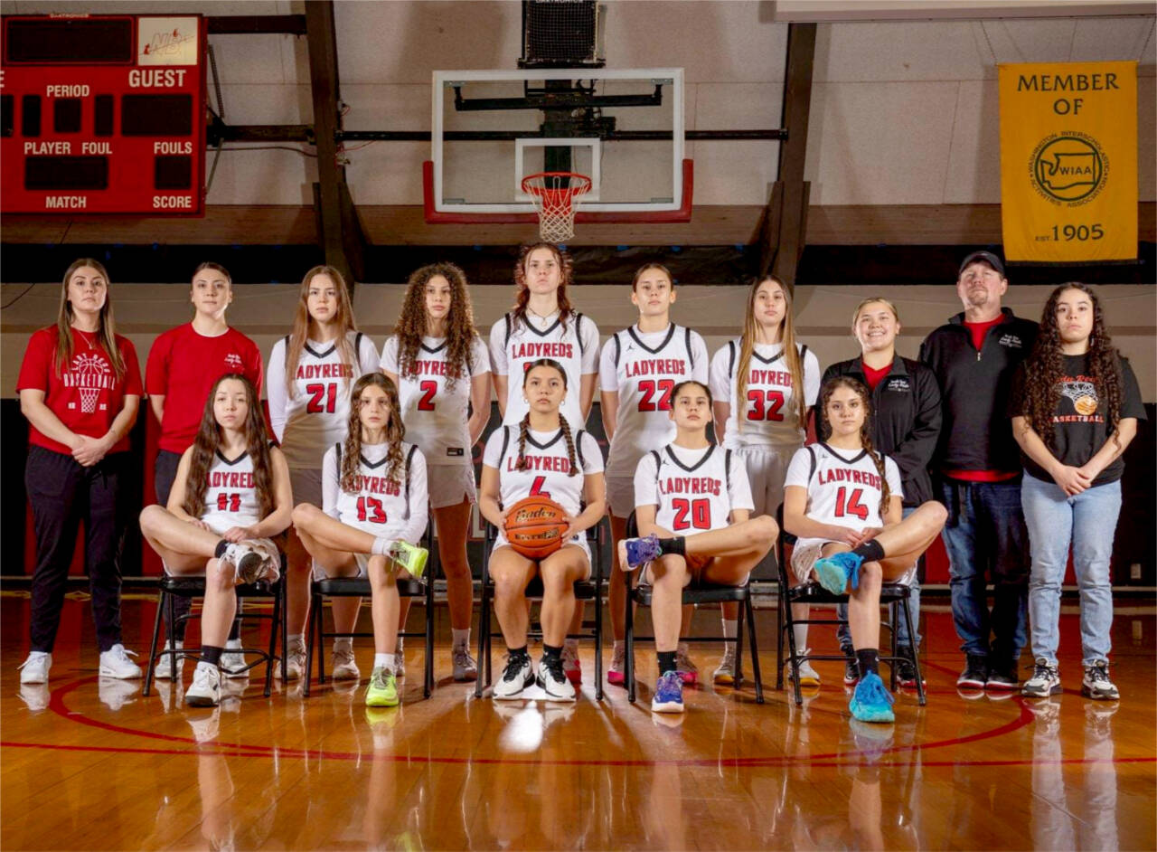 The Neah Bay girls basketball team is looking to win back-to-back state championships at the state tournament this weekend. From left, back row, is head coach Cherish Moss, assistant Cierra Knaus, Wiinuk Martin, Angel Halttunen, Ezrah Ray, Amber Swan, Ryana Moss, assistants Gina McCauley and Tony McCauley and manager Brooklynn Johnson. From left, sitting, are Brianna McGimpsey, Danica Halttunen, Qwaapeys Greene, Caylee Moss and Cerise Moss.