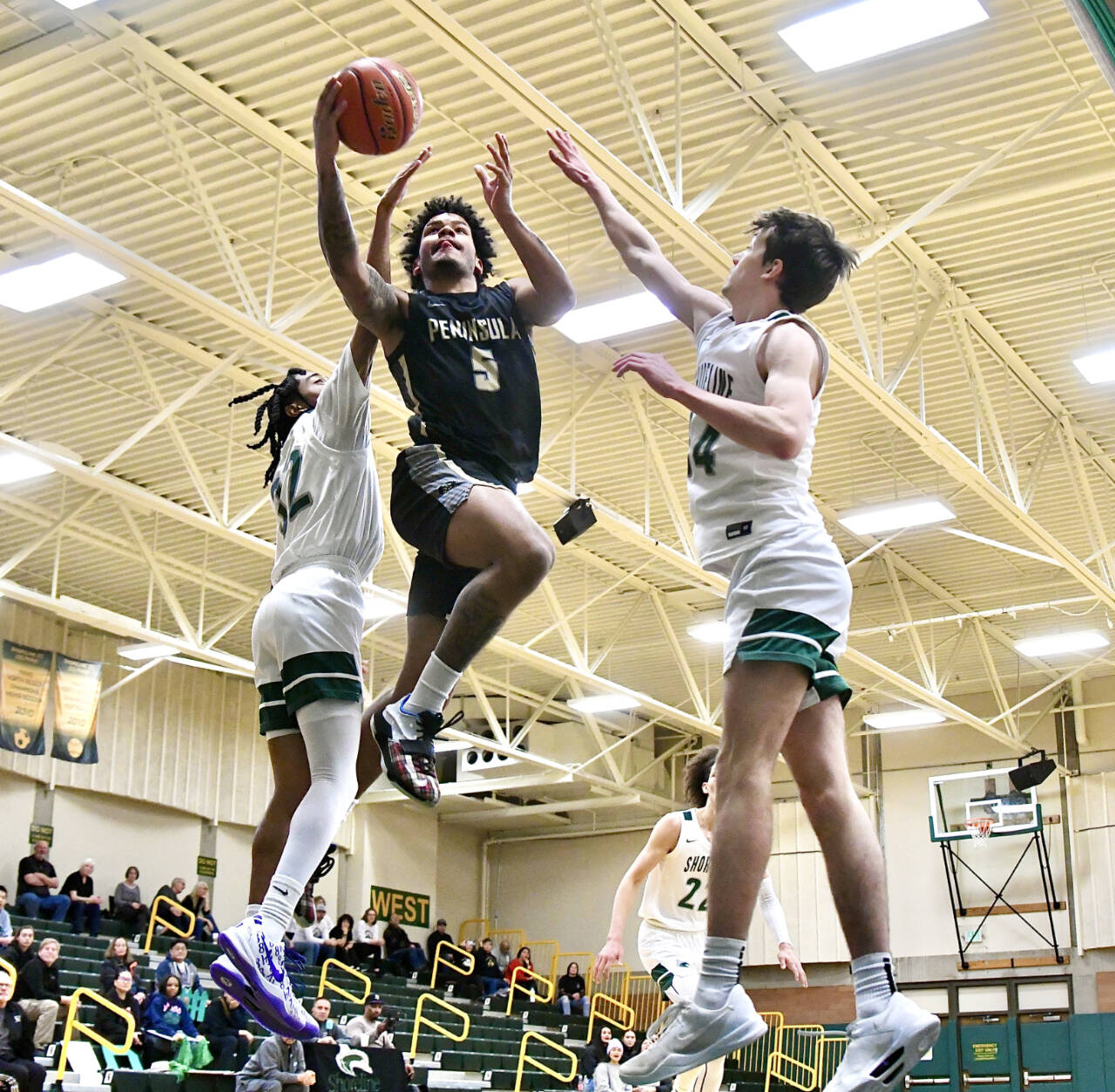 Peninsula College’s Javon Ervin drives to the hoop between Shoreline defenders Jordan Smalls, left, and Derek Nordale, right. Ervin scored 27 as Peninsula won 83-70 to advance to the NWAC Tournament. (Jay Cline/Peninsula College)