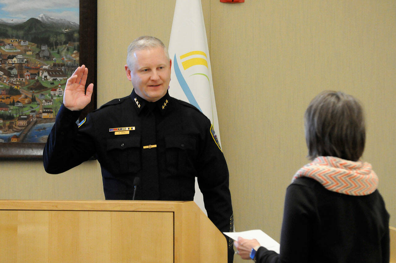Mike Hill takes his oath of office on Friday from acting city clerk Heather Robley to become the City of Sequim’s new police chief. (Matthew Nash/Olympic Peninsula News Group)